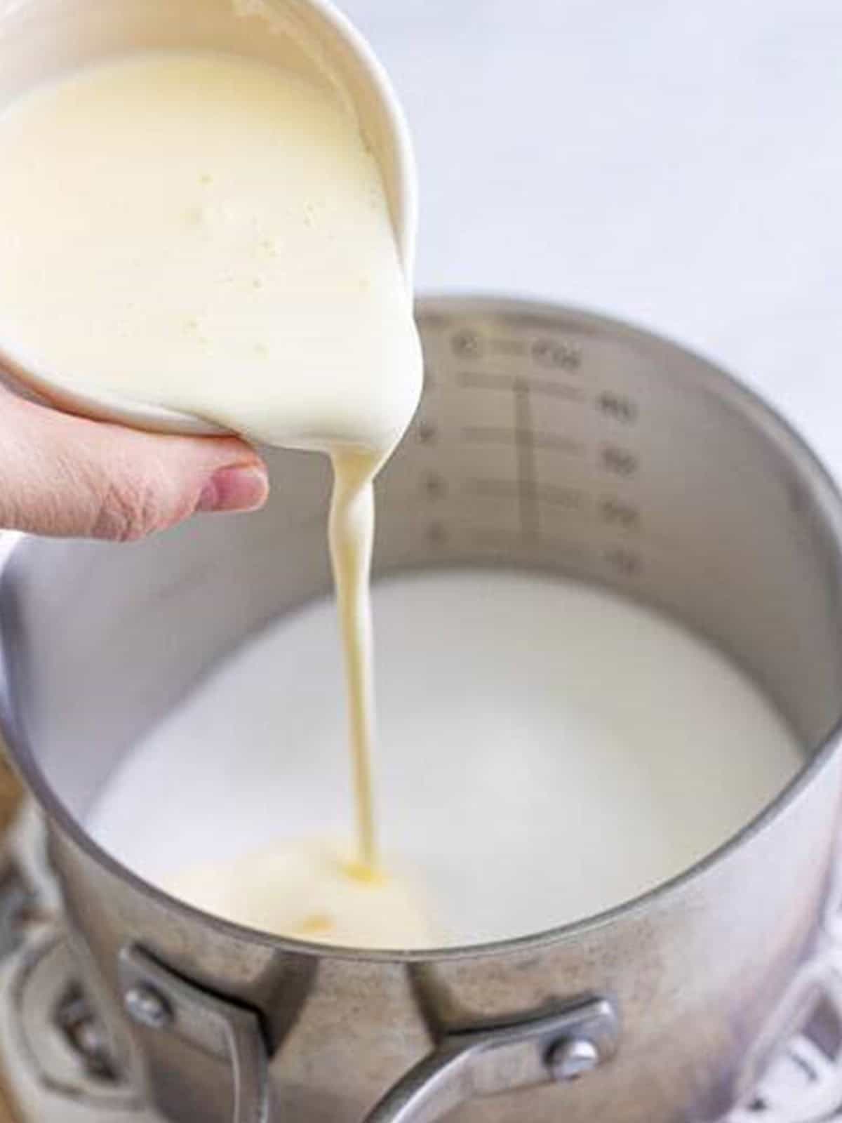 Heavy cream being poured into a saucepan to make the Fireball caramel sauce.
