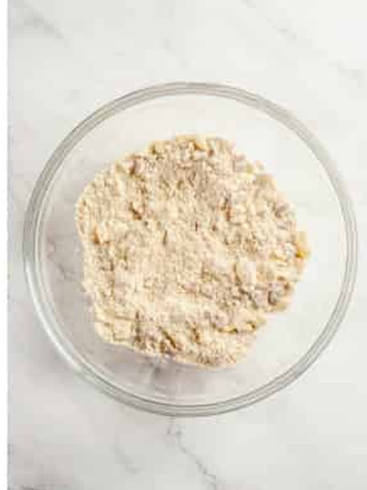 Crumble topping of flour, brown sugar, butter, and pecans mixed in a bowl.