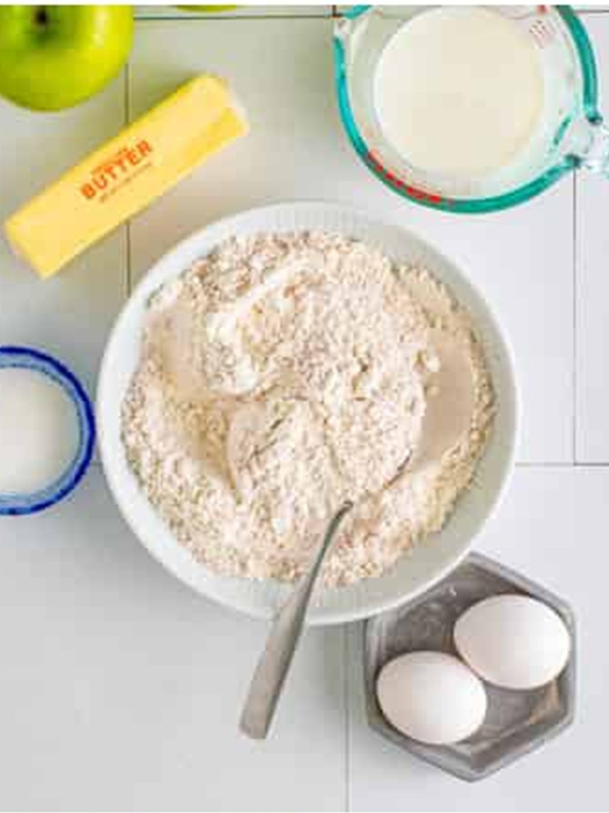 Flour, baking powder, cinnamon, salt, and nutmeg whisked together for apple fritter batter.