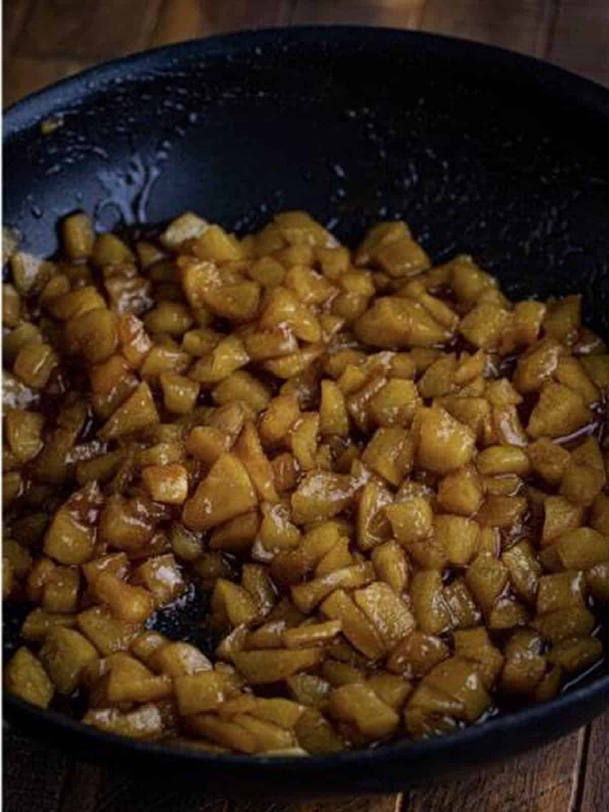 Cooked cinnamon apple topping thickened in a skillet.