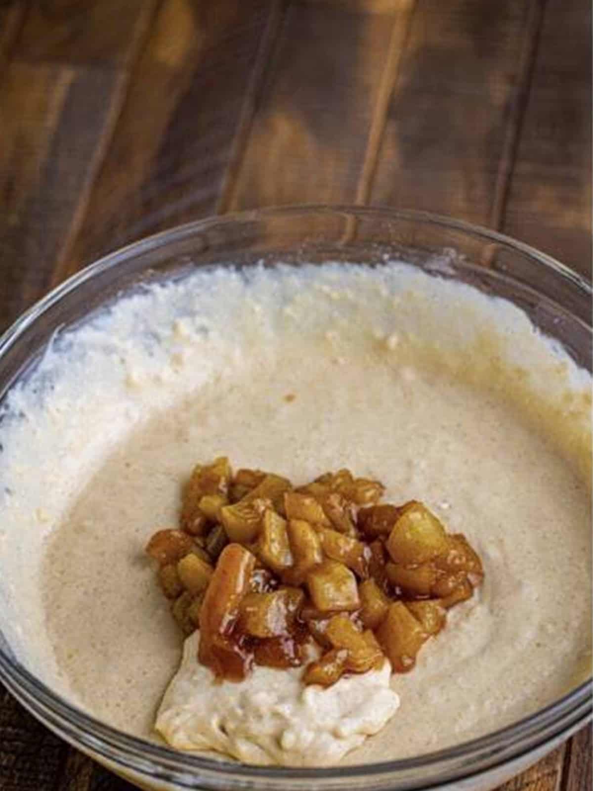 Folding cooked apple topping into the pancake batter.