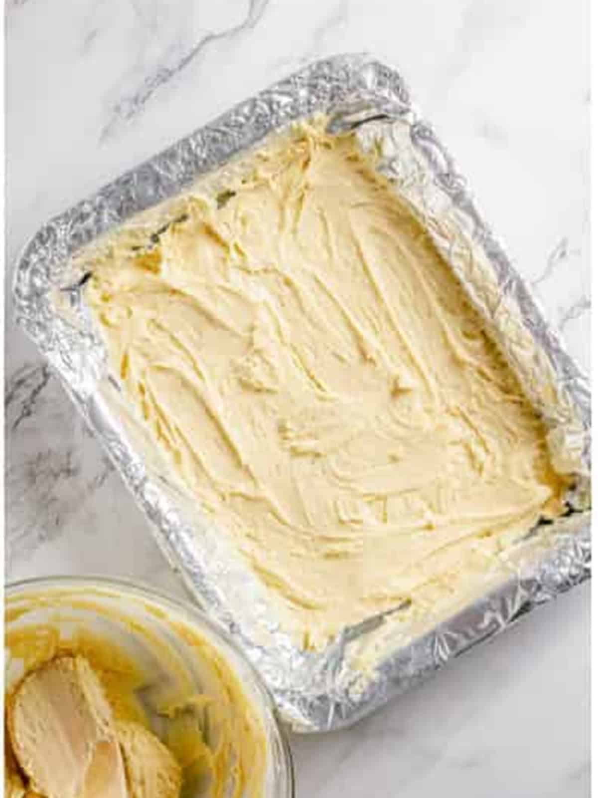 Pressing apple pie bars batter into a foil lined baking pan.