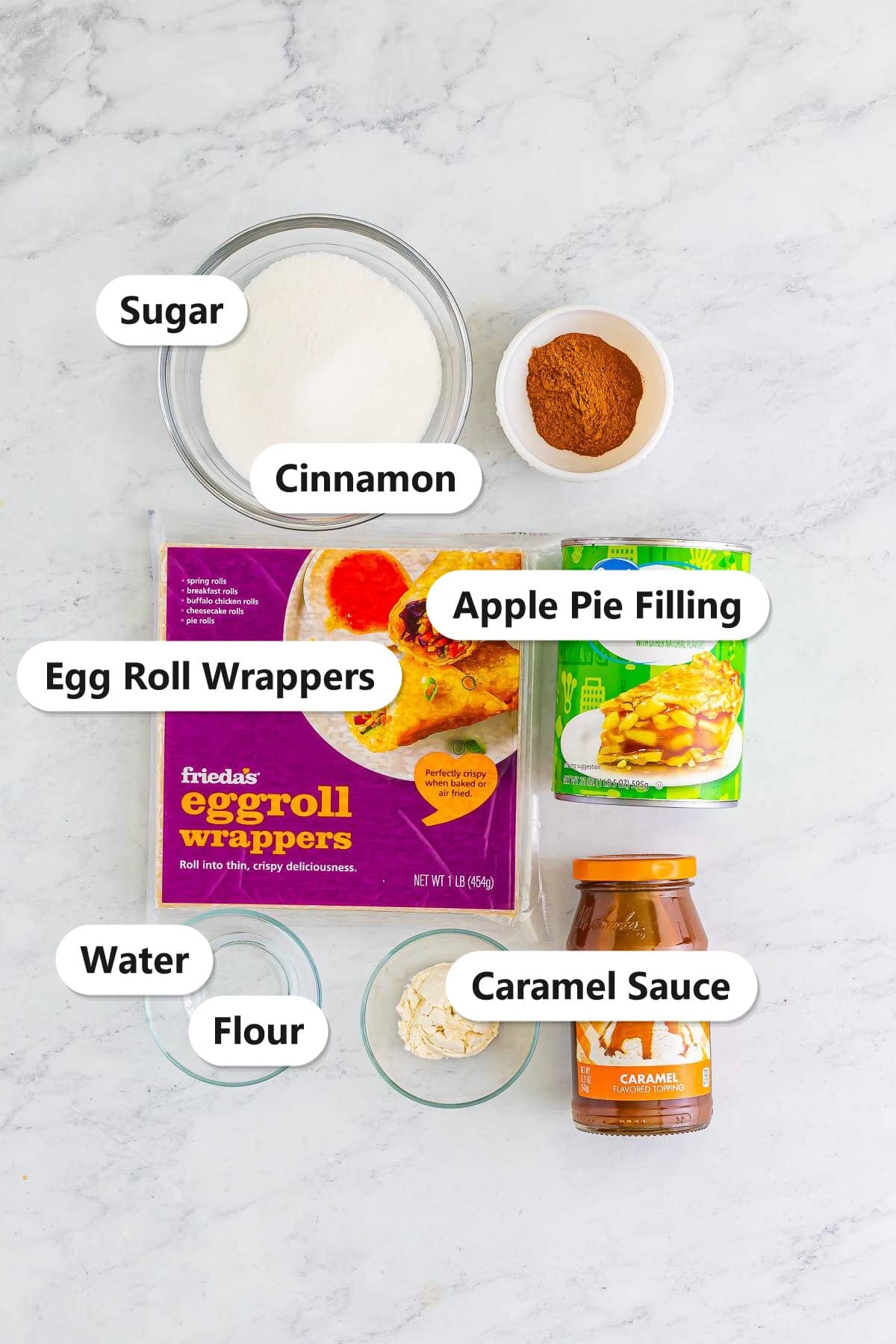 Labeled apple pie egg rolls ingredients including egg roll wrappers, apple pie filling, sugar, cinnamon, flour, water, and caramel sauce.