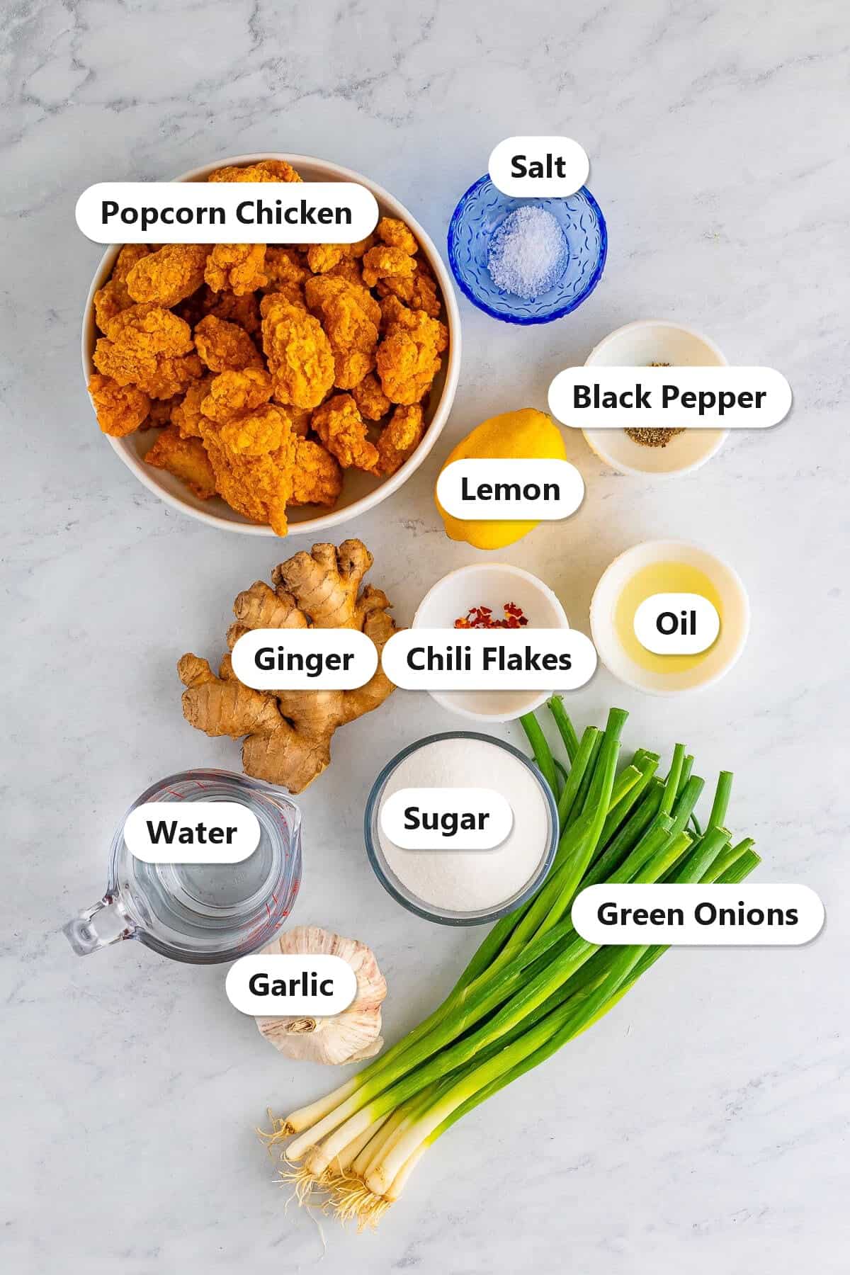 Labeled ingredients for asian lemon chicken including popcorn chicken, ginger, garlic, lemon, green onions, chili flakes, and cornstarch.