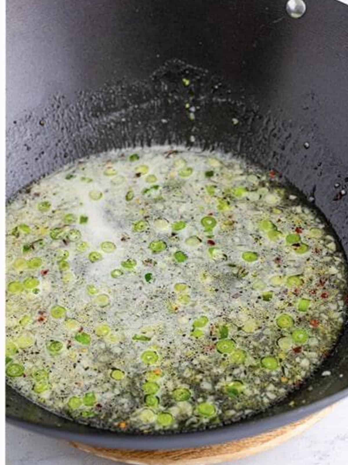 Bringing the lemon sauce to a simmer in the wok.