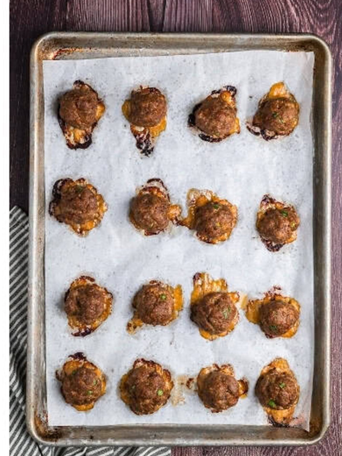 Baked Asian meatballs on a parchment lined baking sheet.