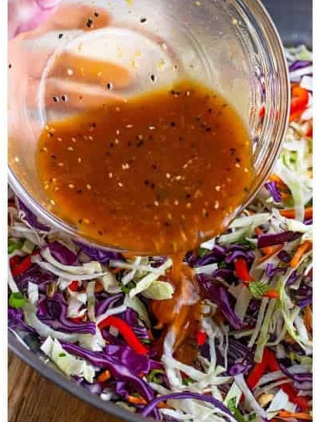 Dressing being poured over the slaw vegetables.