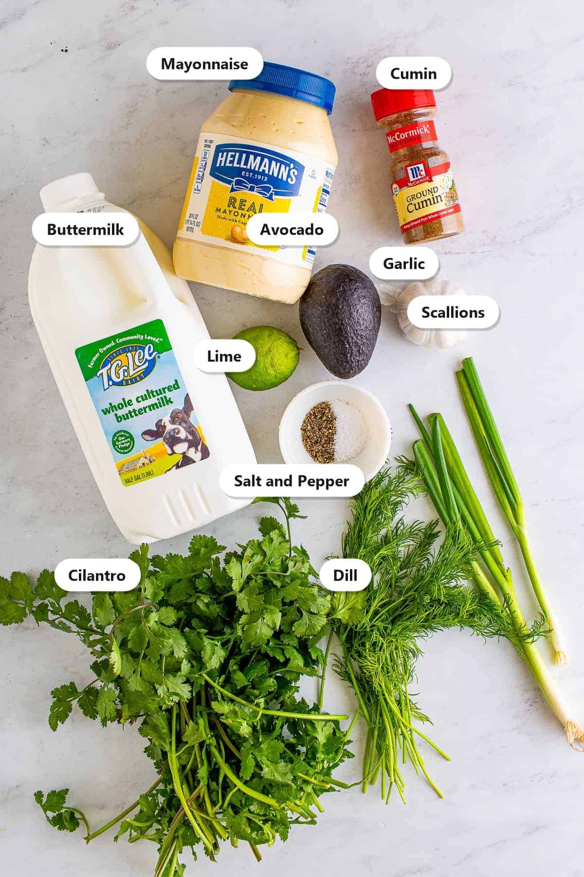 Labeled ingredients for avocado ranch including buttermilk, mayonnaise, avocado, cilantro, scallions, garlic, lime, dill, cumin, and salt and pepper.