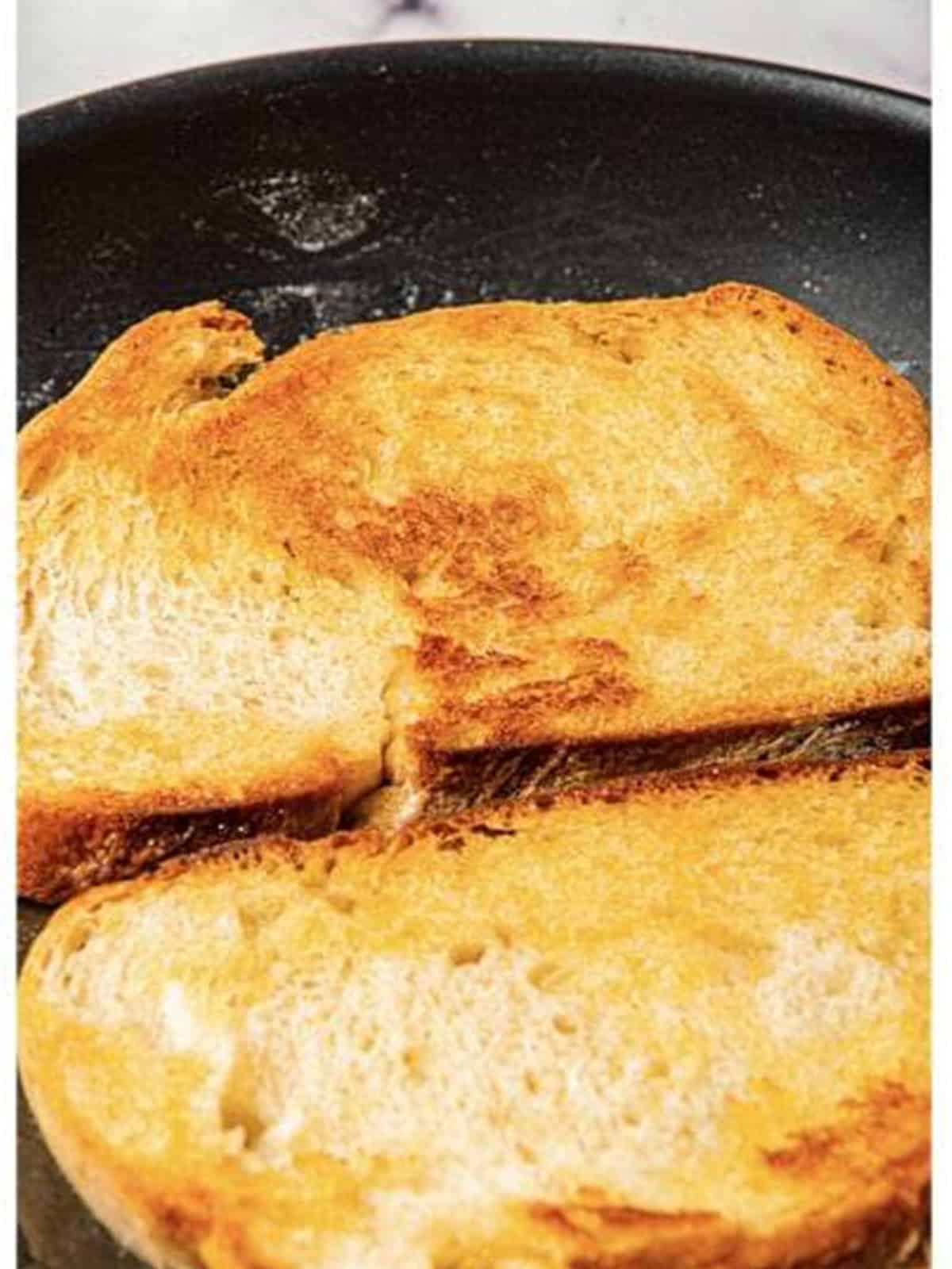 Golden, crisp toasted bread set aside on a plate for avocado toast.