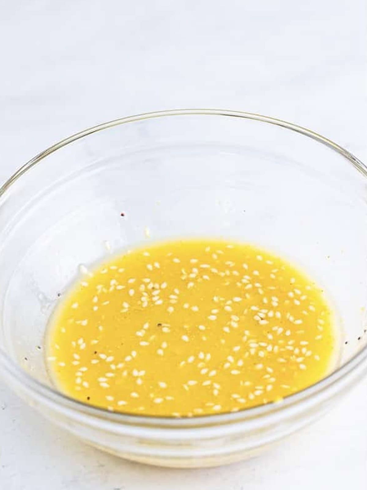 Savory butter glaze with poppy and sesame seeds stirred in a bowl.