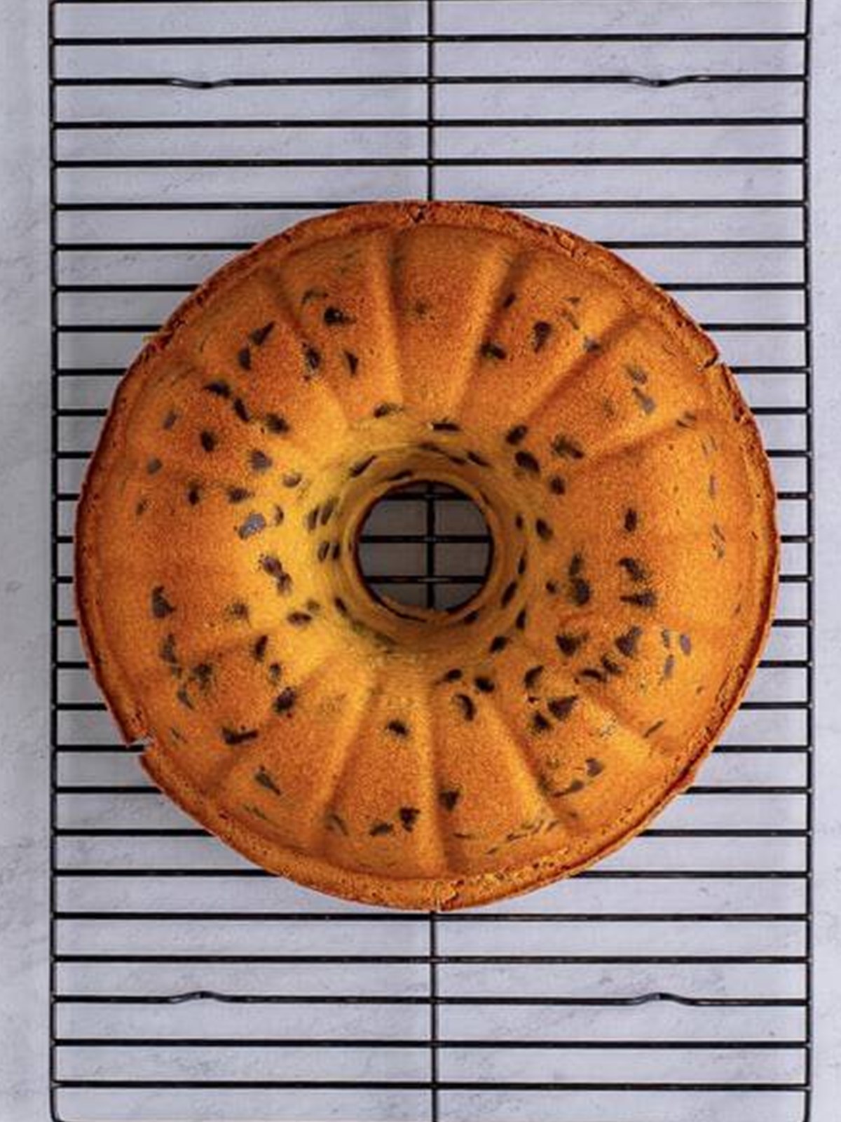 Baked chocolate chip pound cake bundt on a wire rack.