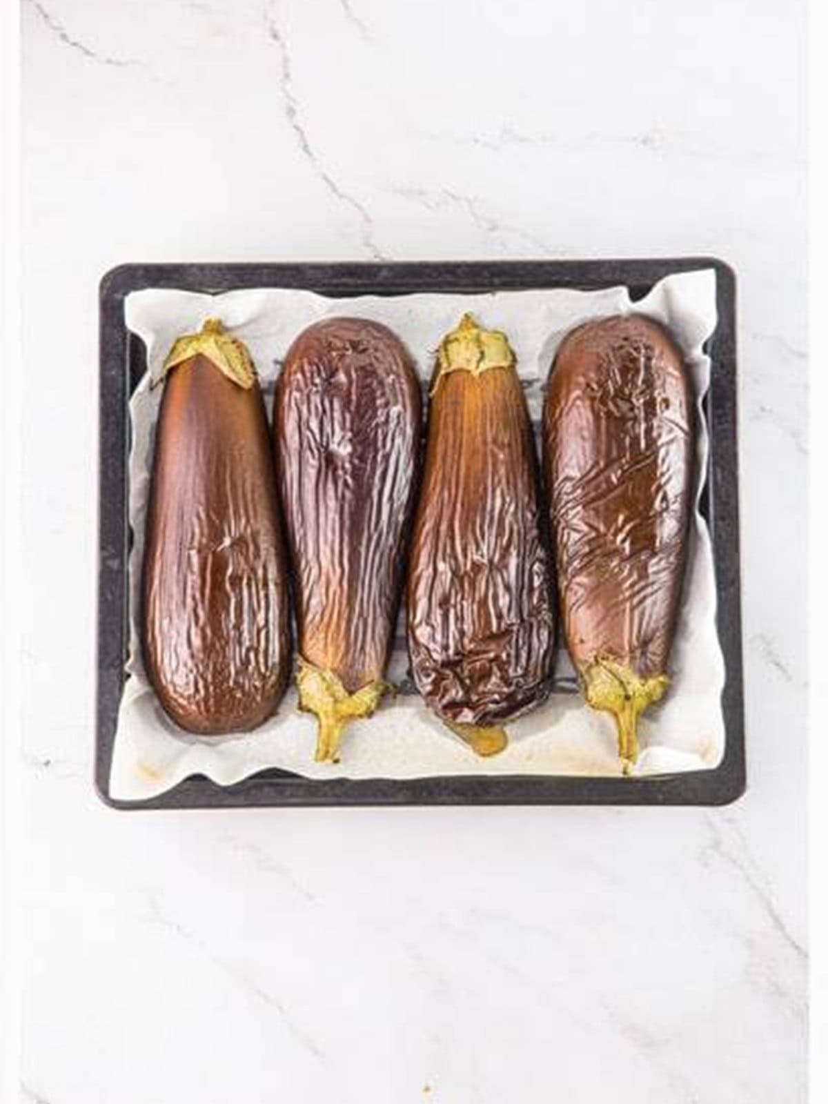Roasted, charred eggplant halves fresh from the oven for baba ganoush.