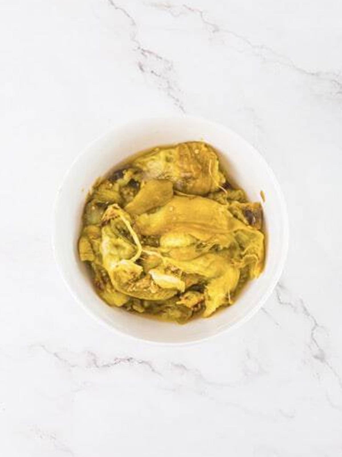 Soft roasted eggplant flesh scooped into a food processor for baba ganoush.