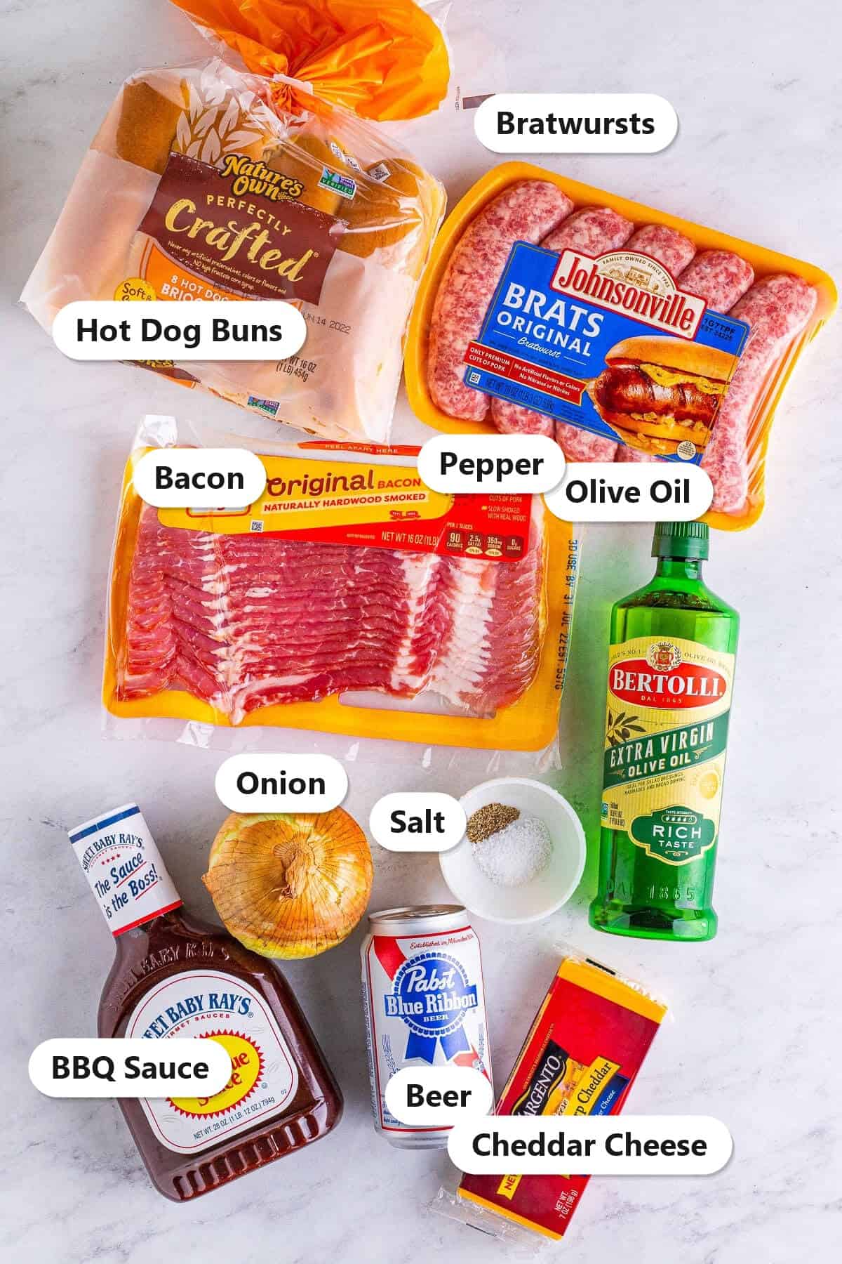 Labeled ingredients for cheese stuffed bacon wrapped brats including bratwursts, bacon, cheddar cheese, hot dog buns, BBQ sauce, beer, onion, and olive oil.