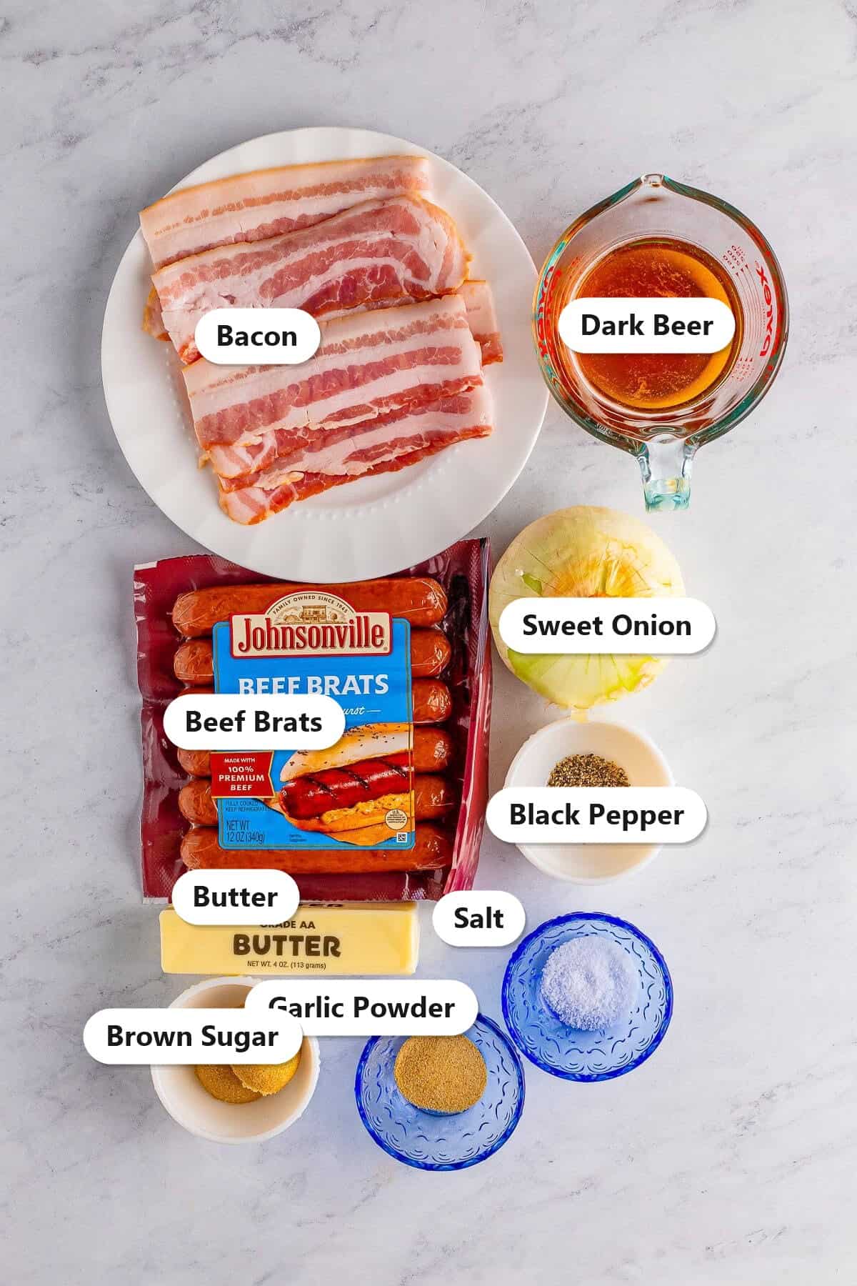 Labeled ingredients for bacon wrapped bratwurst sandwiches including beef brats, bacon, sweet onion, dark beer, butter, and brown sugar.