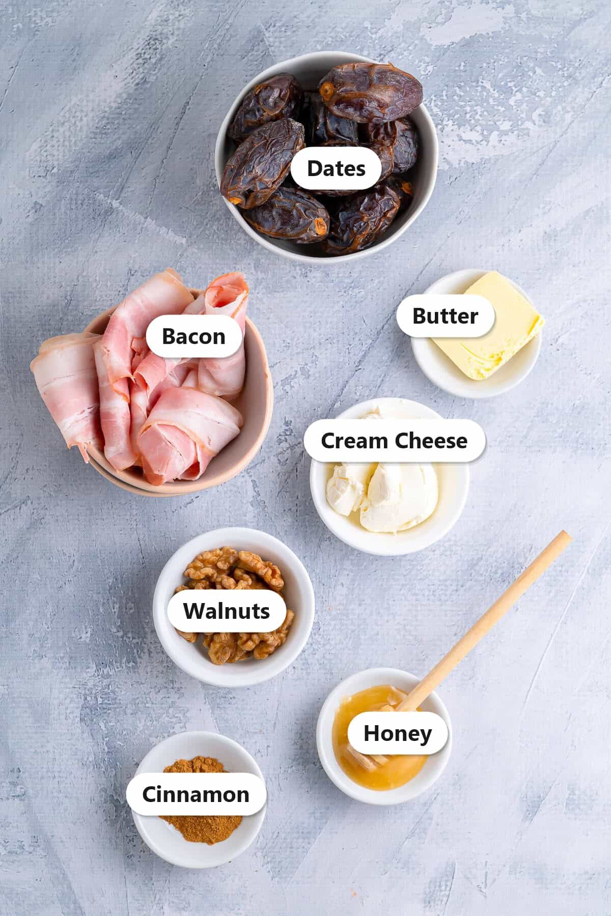 Labeled ingredients for bacon wrapped dates including Medjool dates, bacon, cream cheese, walnuts, butter, honey, and cinnamon.