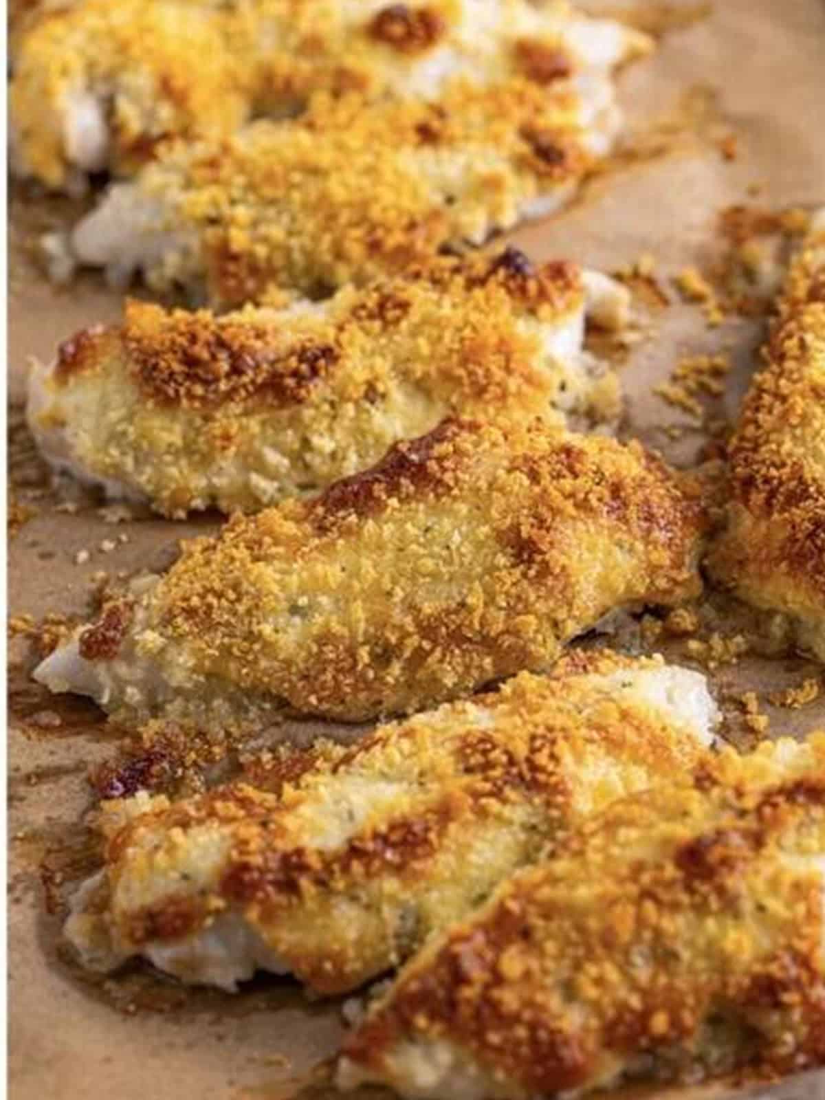 Golden brown baked chicken tenders fresh out of the oven on the sheet tray.