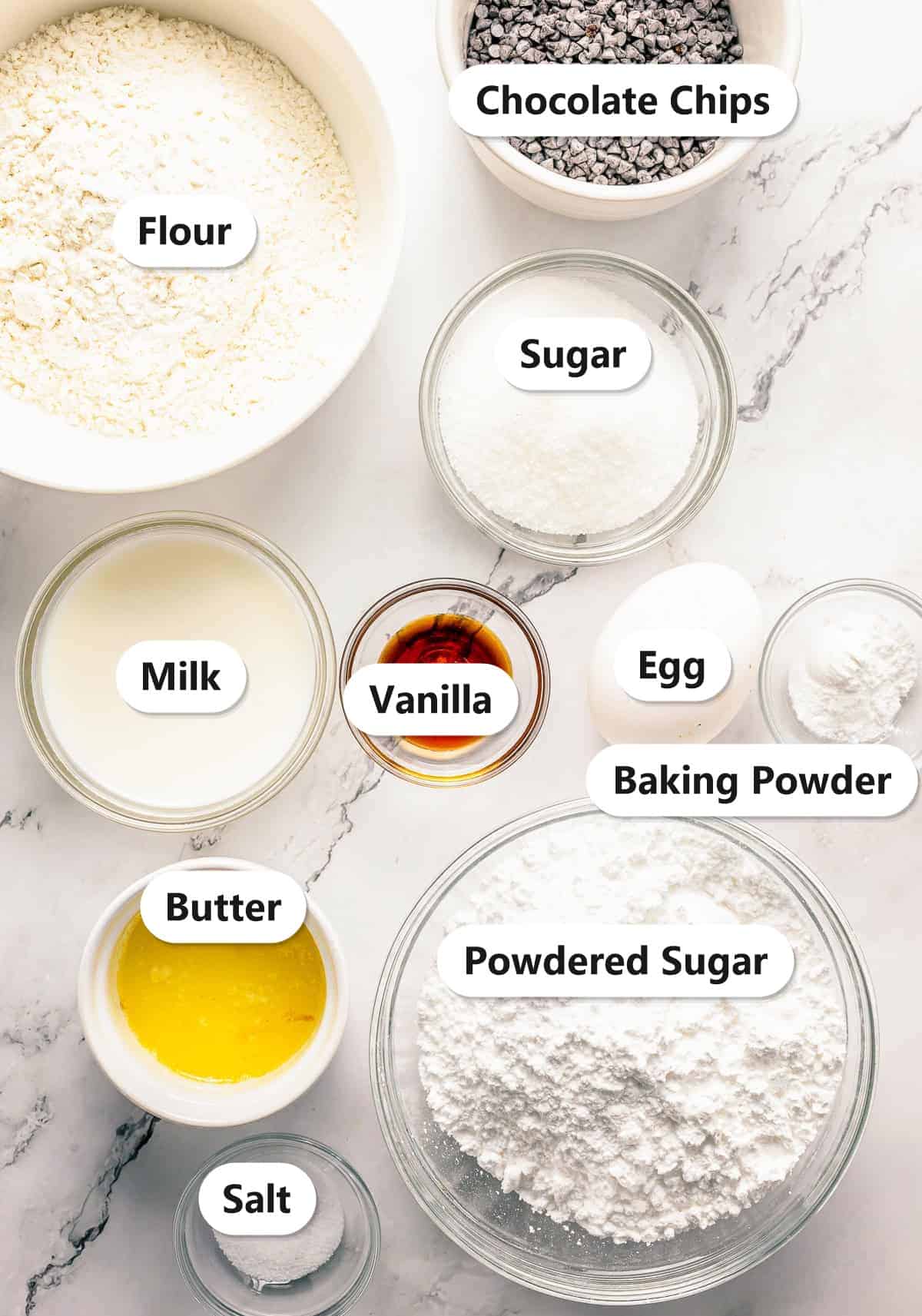 Labeled ingredients for baked donut holes including flour, sugar, milk, egg, butter, chocolate chips, and powdered sugar.
