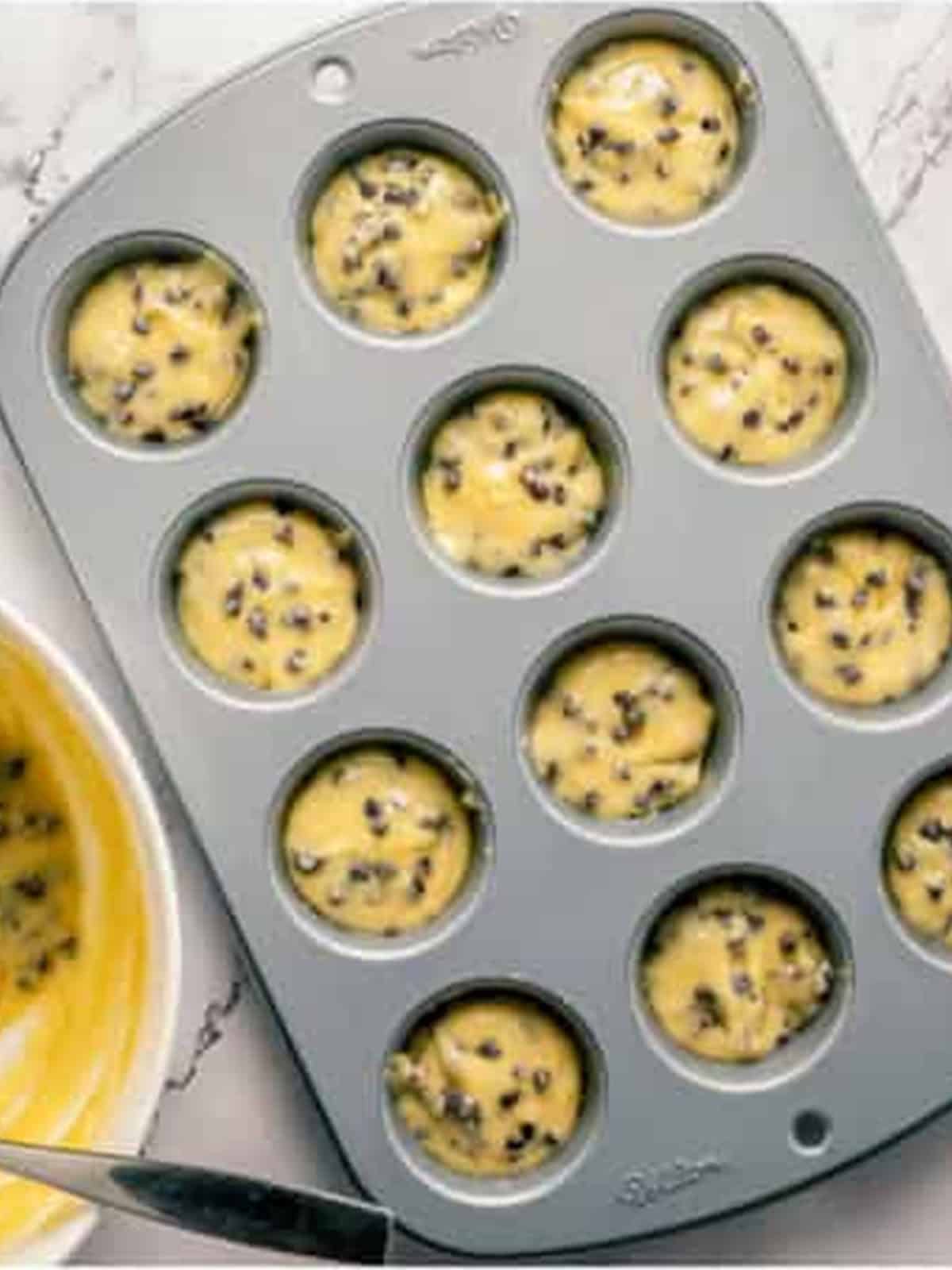 Donut hole batter filling a mini muffin tin.