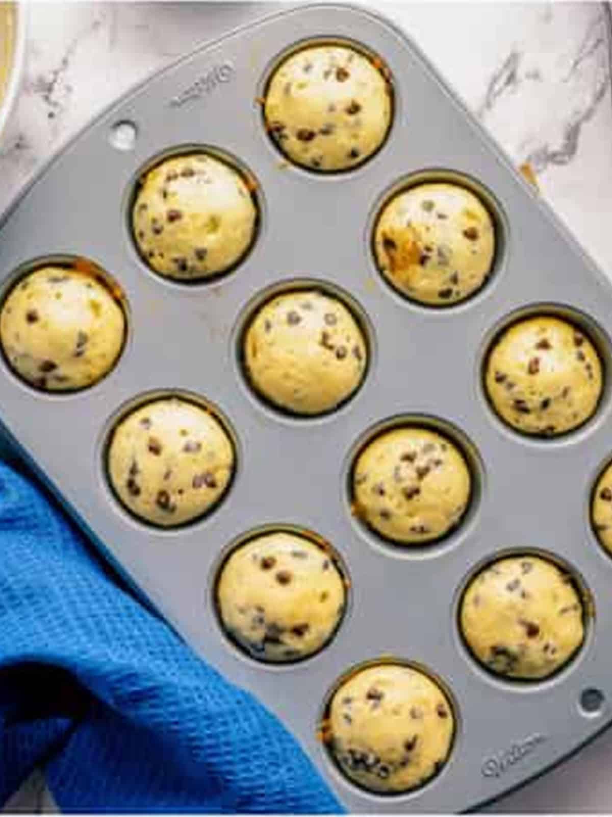 Baked chocolate chip donut holes in a mini muffin tin.