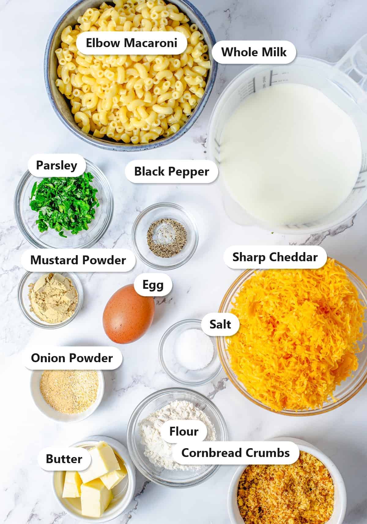 Elbow macaroni, whole milk, sharp cheddar, cornbread crumbs, egg, butter, flour, and seasonings labeled for Baked Mac and Cheese.