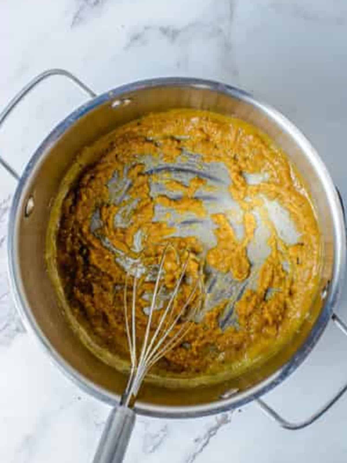 Whisking butter and flour into a golden roux in a saucepan for Baked Mac and Cheese.