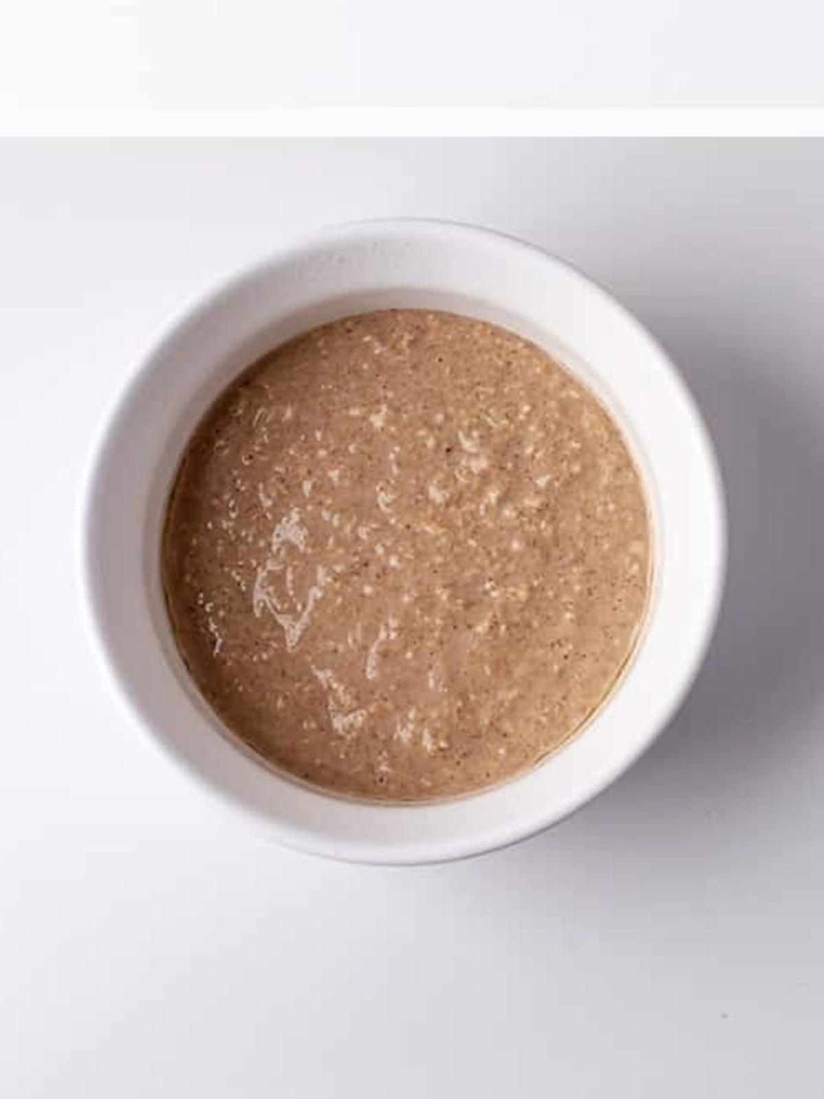 Baked oats batter poured into a ramekin before baking.