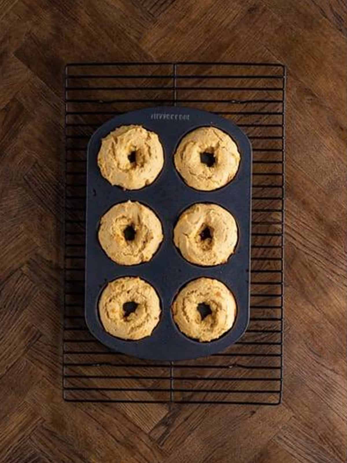 Baked peanut butter donuts cooling on a wire rack.