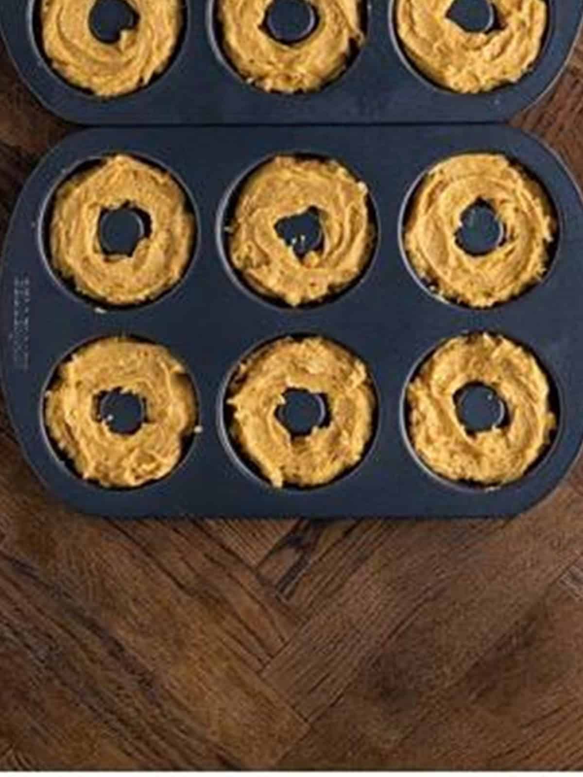 Peanut butter donut batter piped into a donut baking pan.