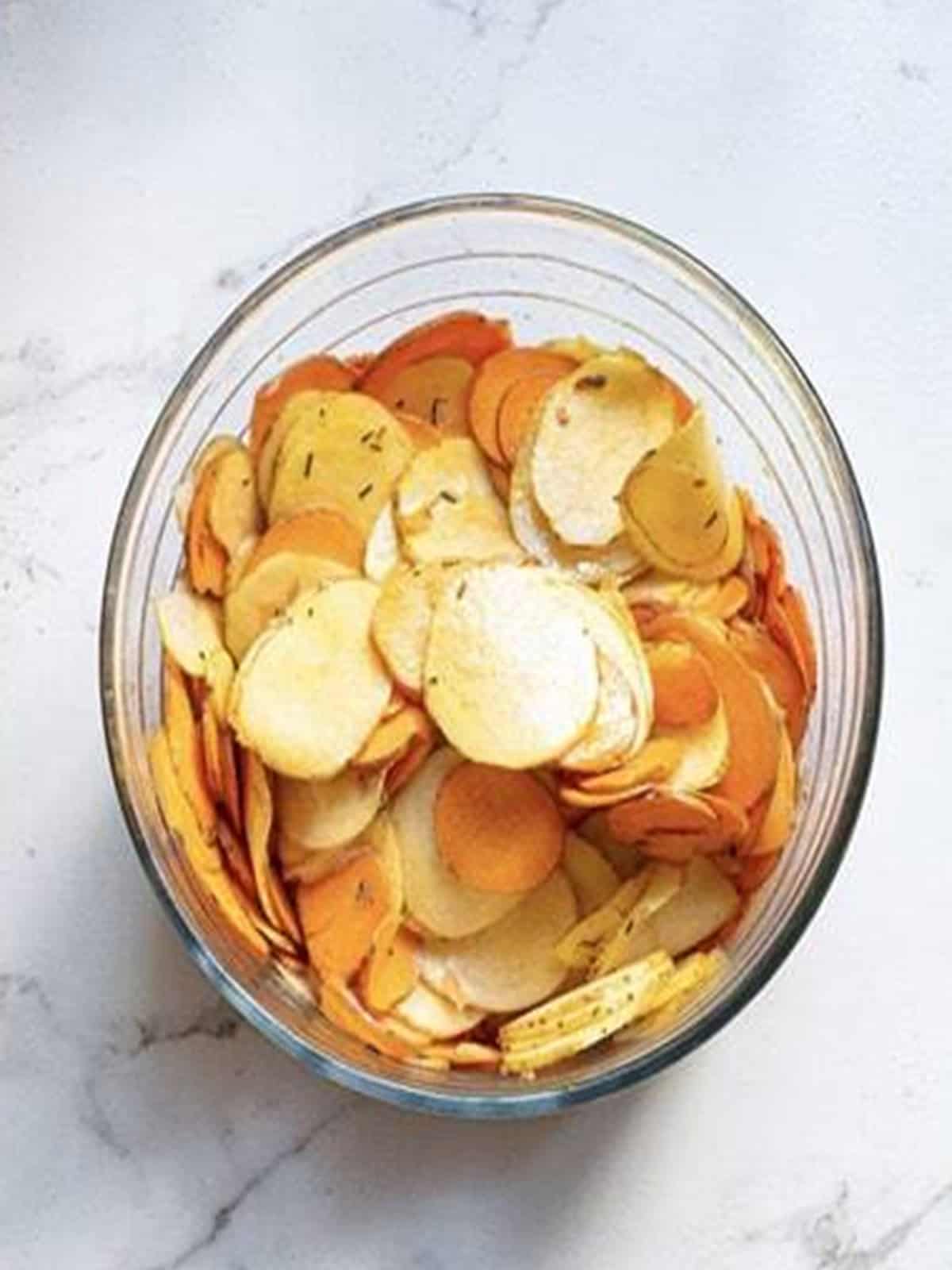 Sliced potatoes tossed in the seasoned olive oil mixture.