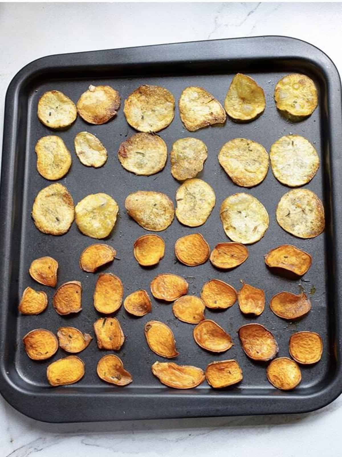 Crispy baked potato chips on a baking sheet fresh from the oven.