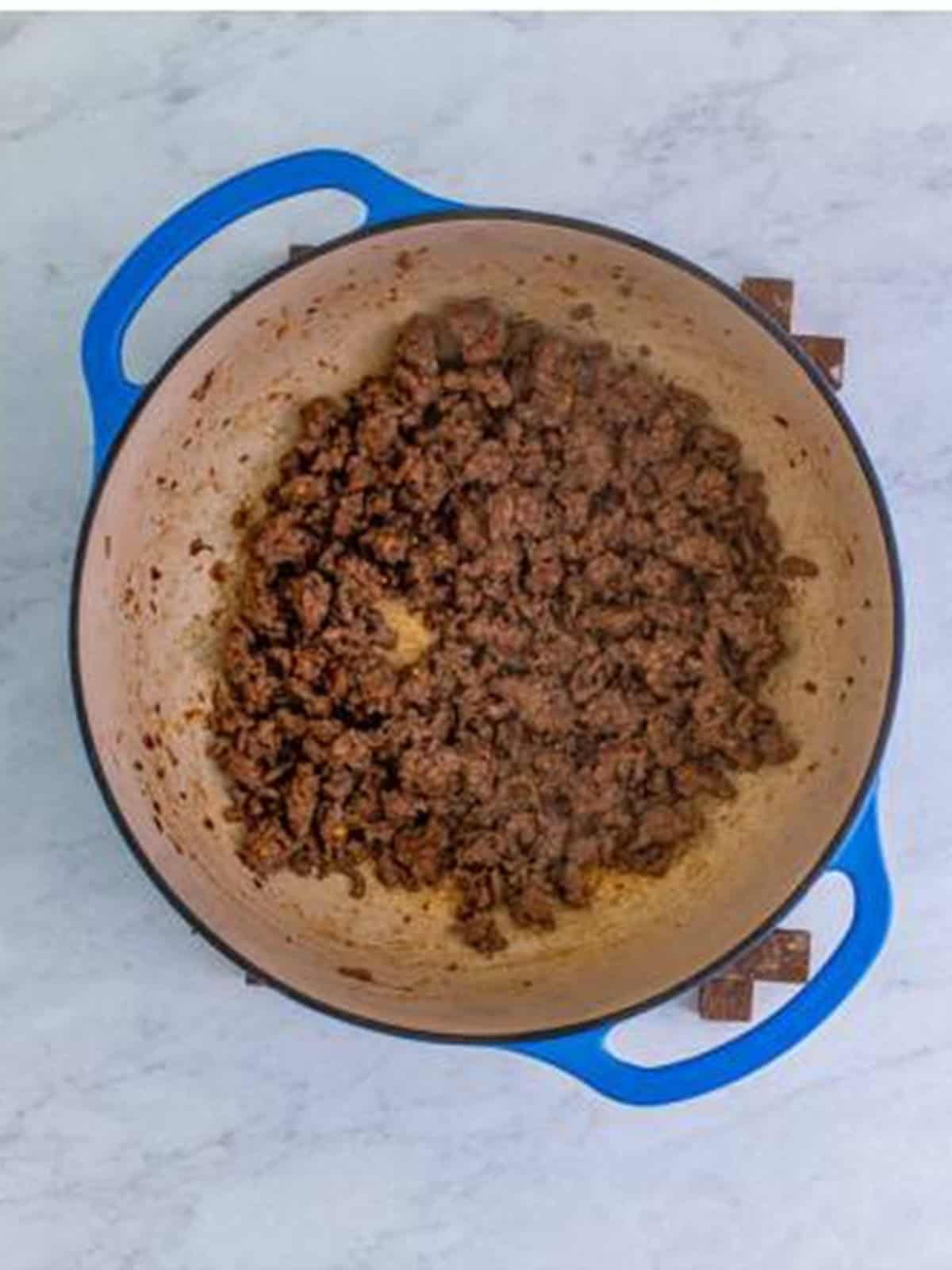 Seasoned ground beef browning in a Dutch oven for baked ziti