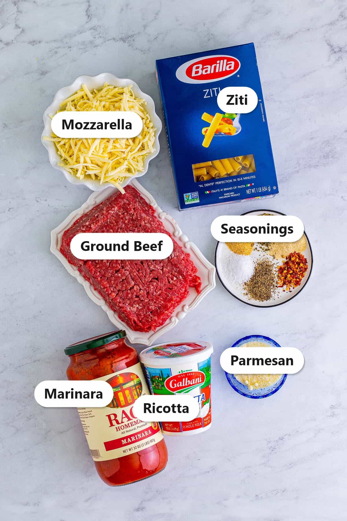 Labeled baked ziti ingredients including ziti, ground beef, marinara, ricotta, mozzarella, and parmesan