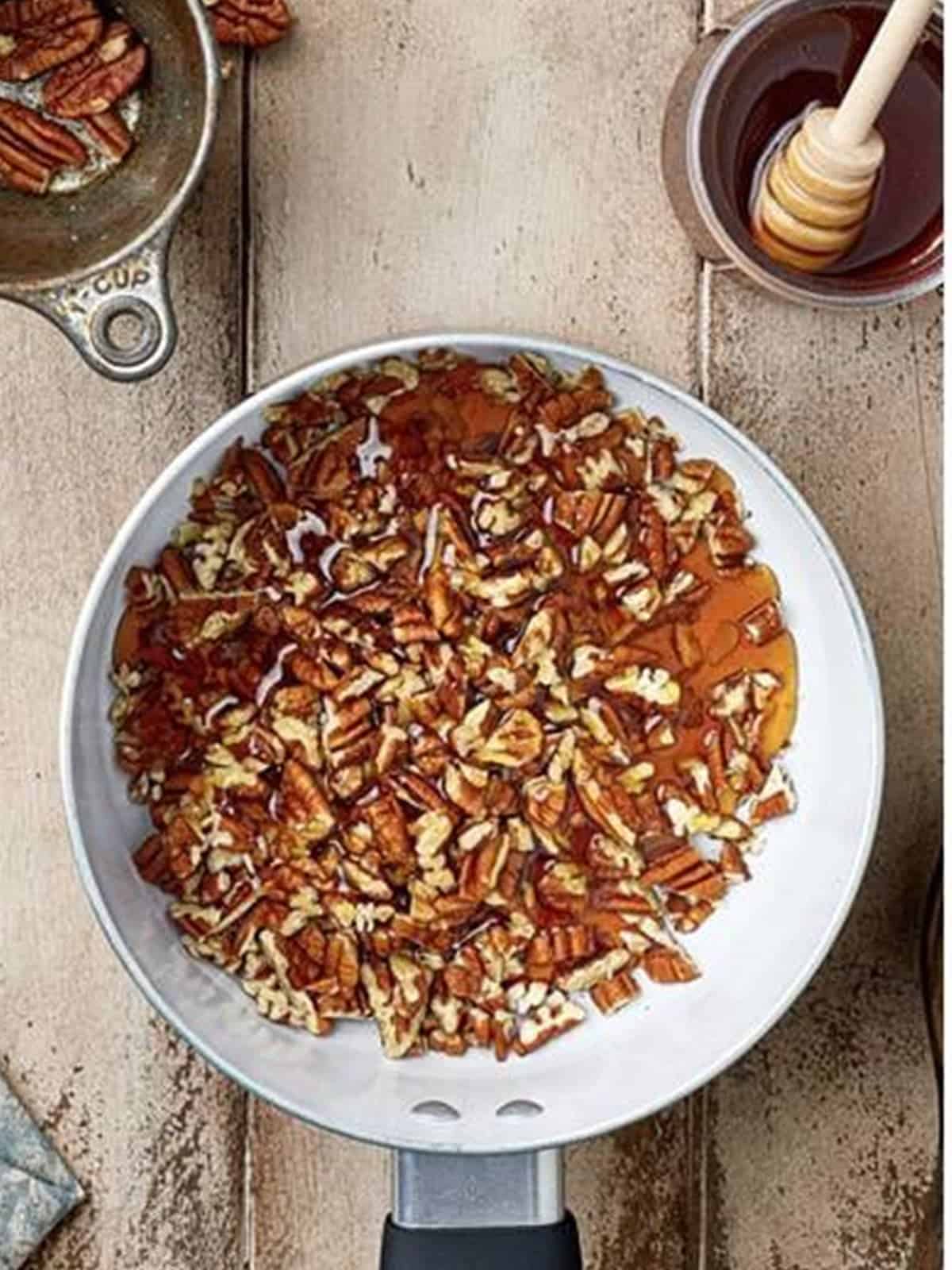 Pecans, honey, and water combined in a pan for the Baklava Bites topping.