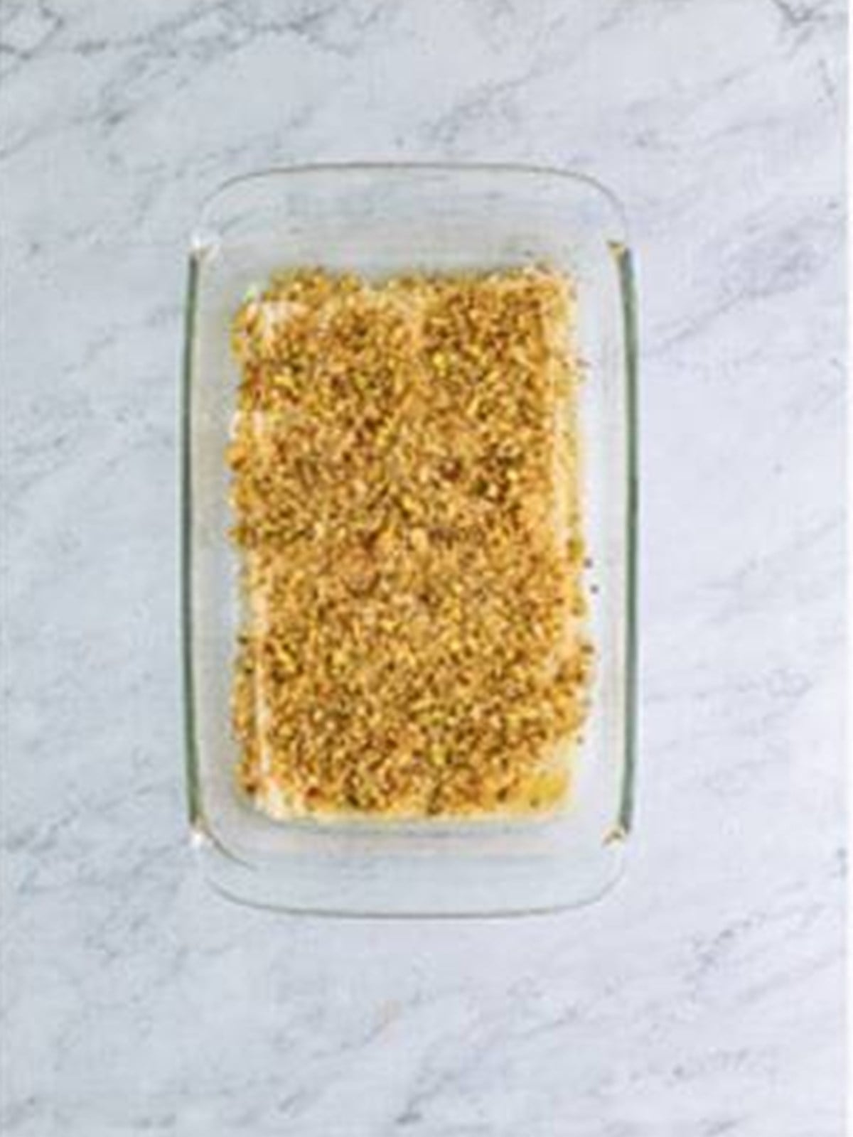 A layer of chopped nuts spread over buttered phyllo dough