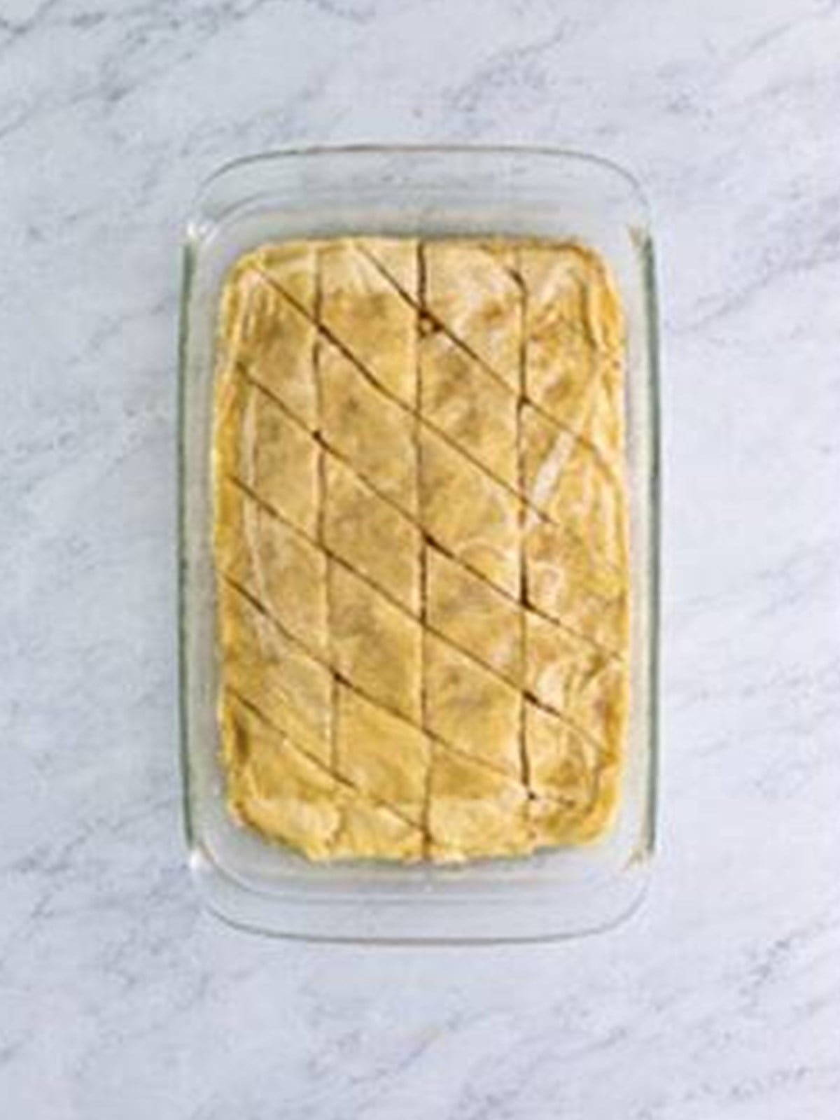 Unbaked baklava scored into a diamond pattern before baking