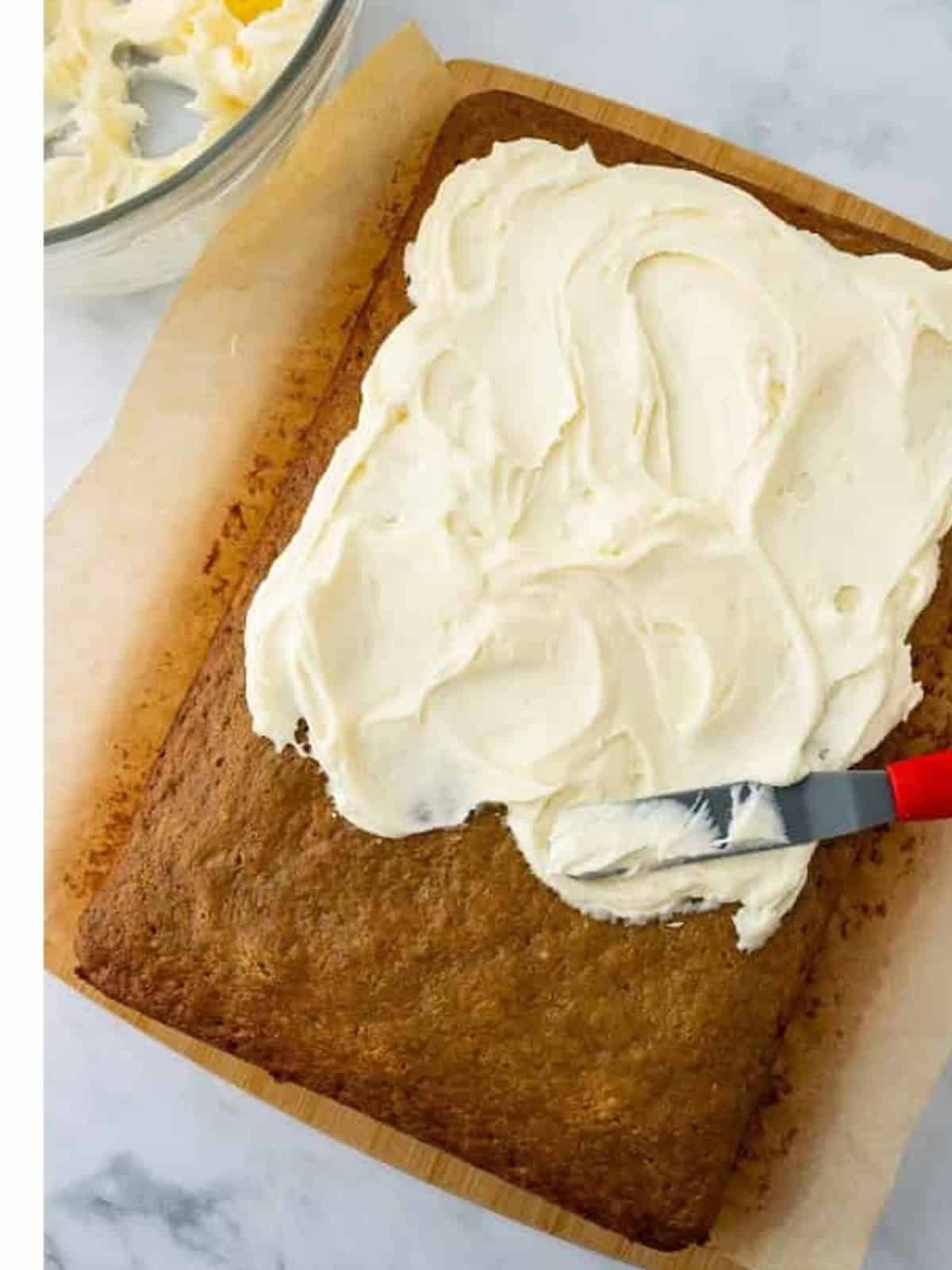 Cream cheese frosting spread over the top of baked banana bars.