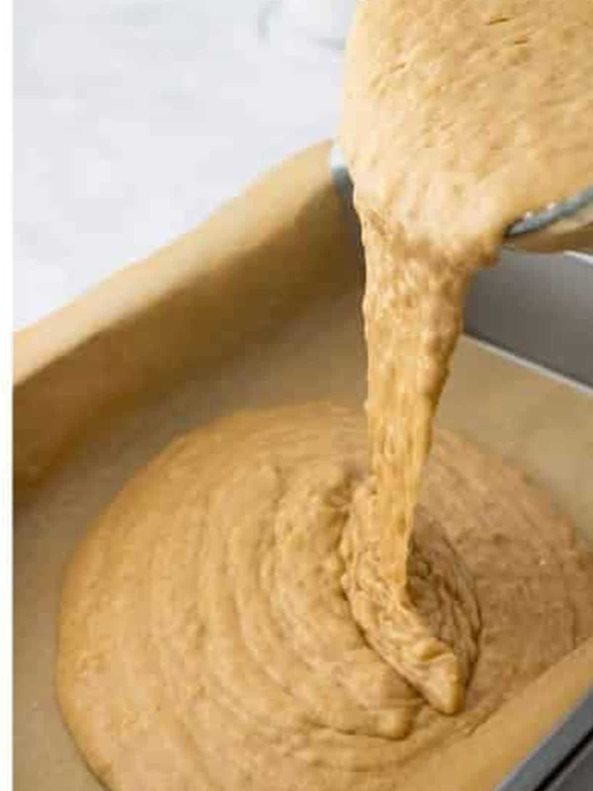 Banana bar batter poured into a parchment lined baking pan.