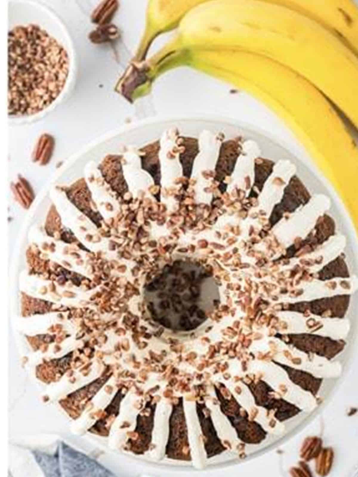 Finished banana bundt cake topped with chopped pecans viewed from above.