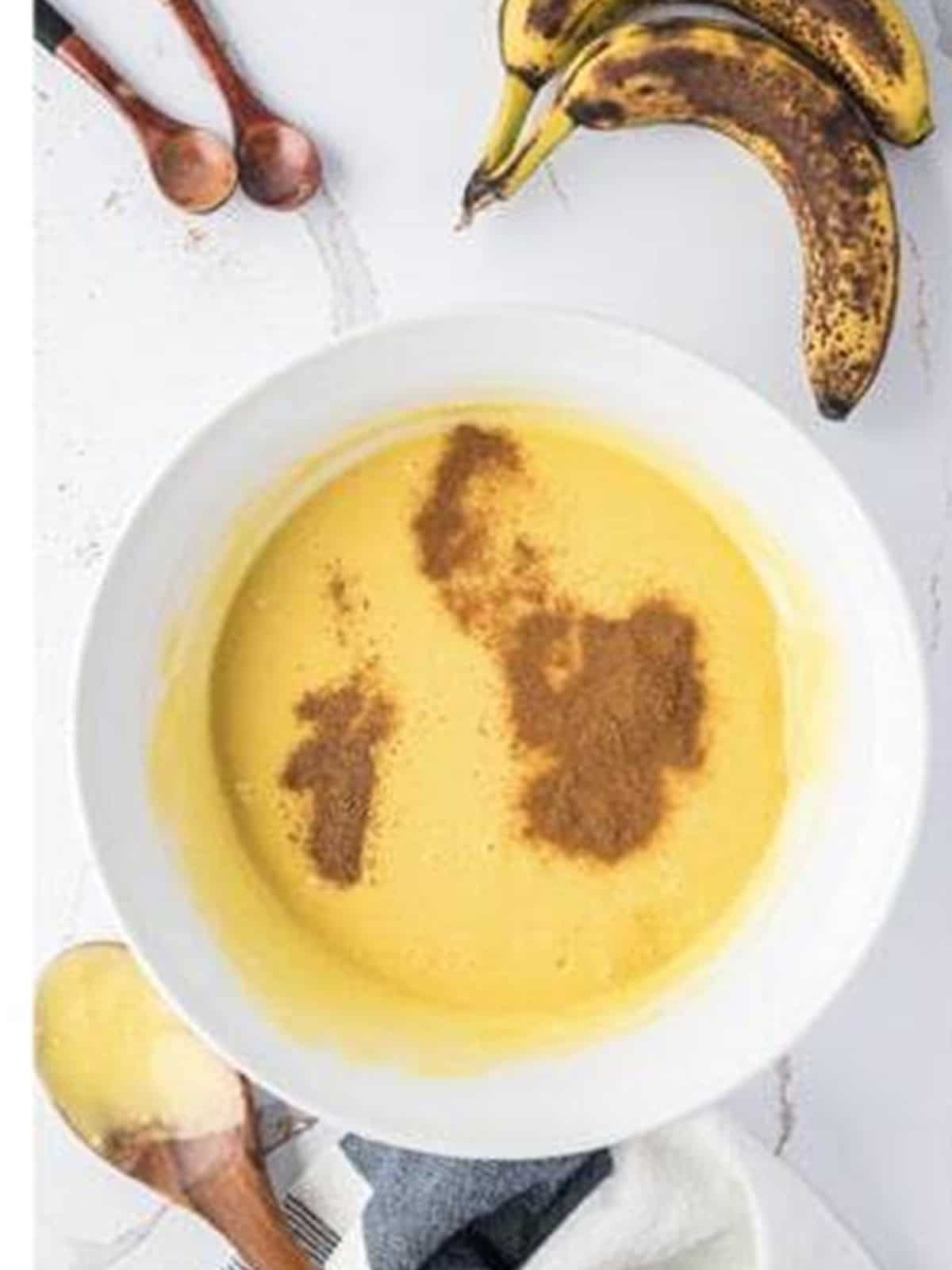 Cinnamon and nutmeg sprinkled over the prepared cake mix batter.