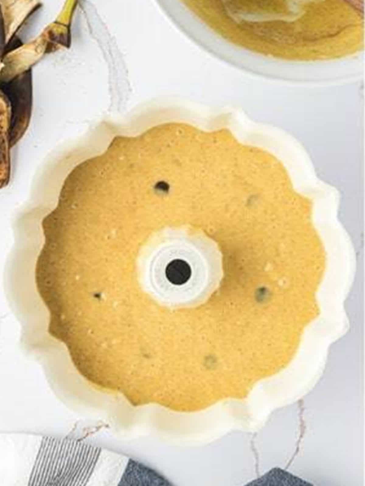 Banana cake batter poured into a greased bundt pan ready to bake.