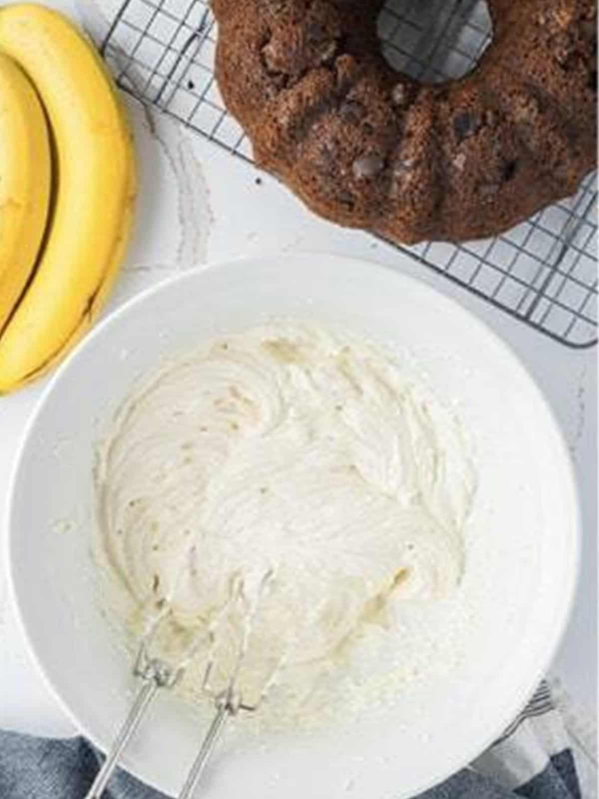 Cream cheese frosting whipped light and airy in a white bowl.