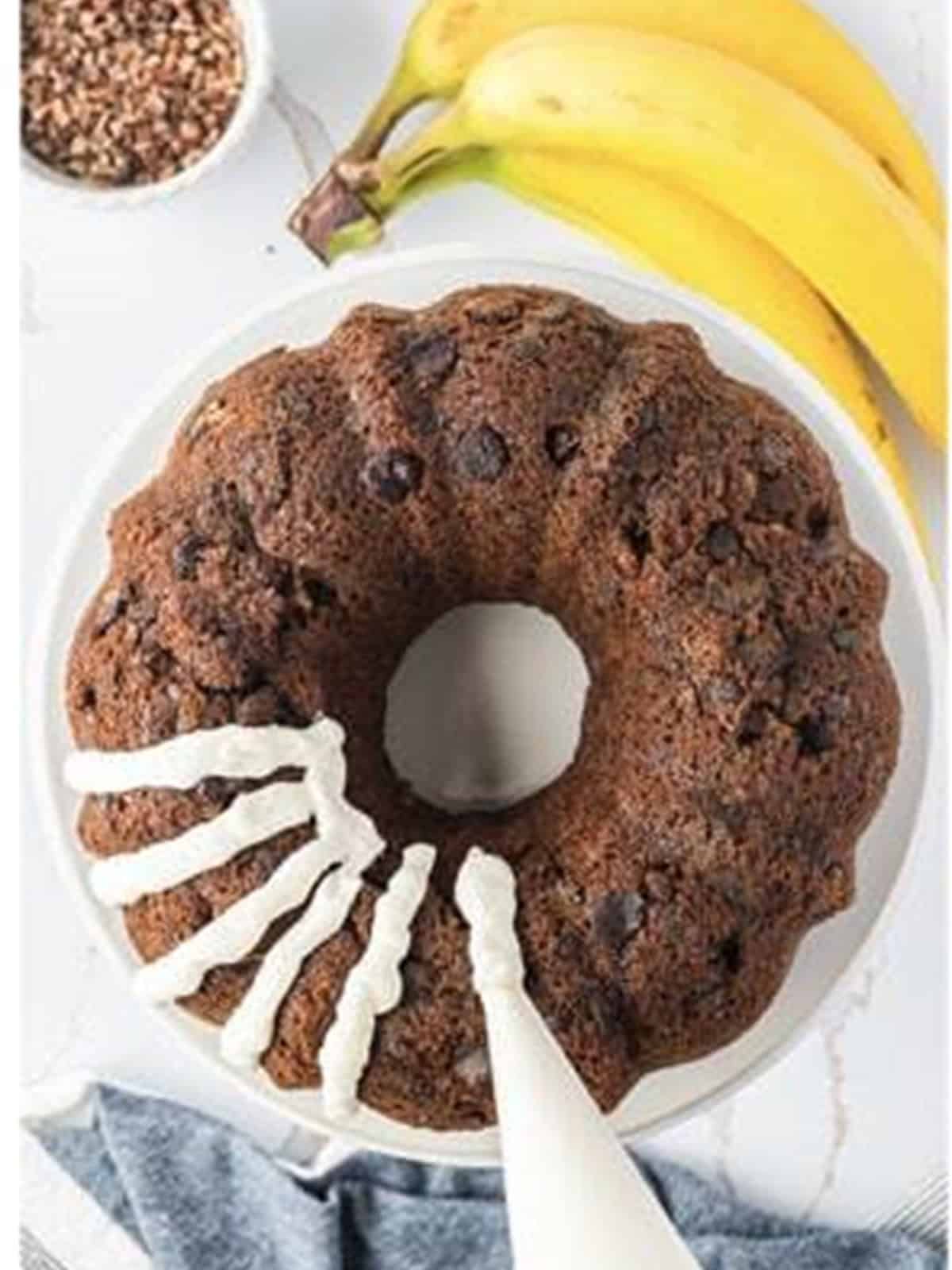 Cream cheese frosting piped in thick stripes over the cooled banana bundt cake.
