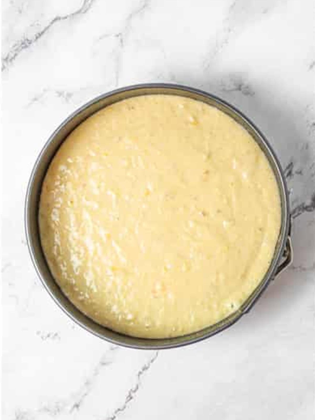 Banana cake batter poured into a round cake pan.
