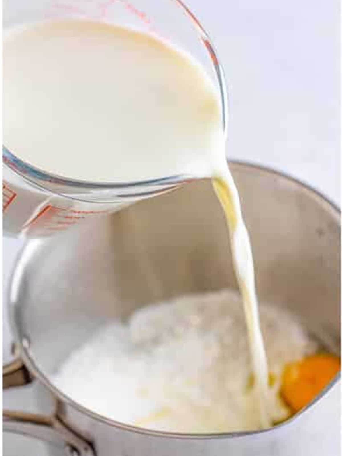 Milk poured into a saucepan with sugar, cornstarch, and egg to make banana cream pie pudding.