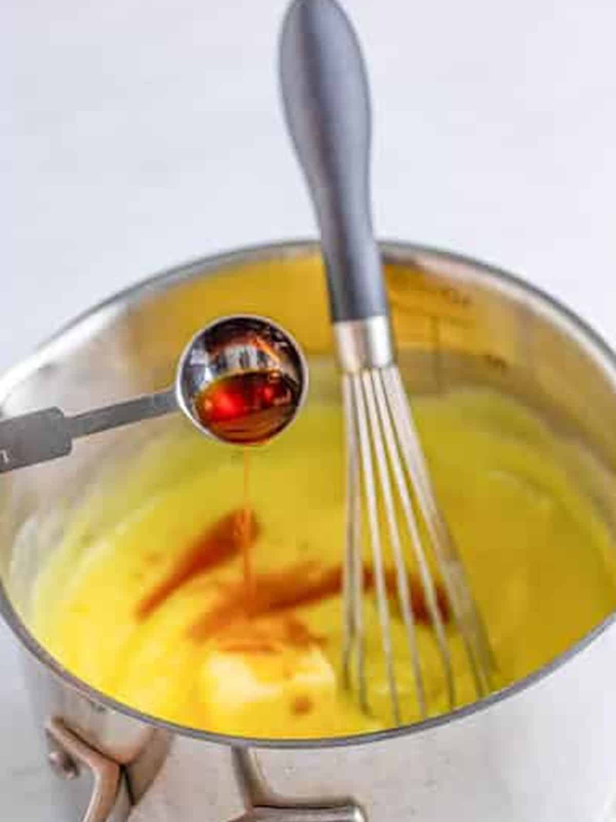 Vanilla whisked into thickened vanilla pudding in a saucepan for banana cream pie.