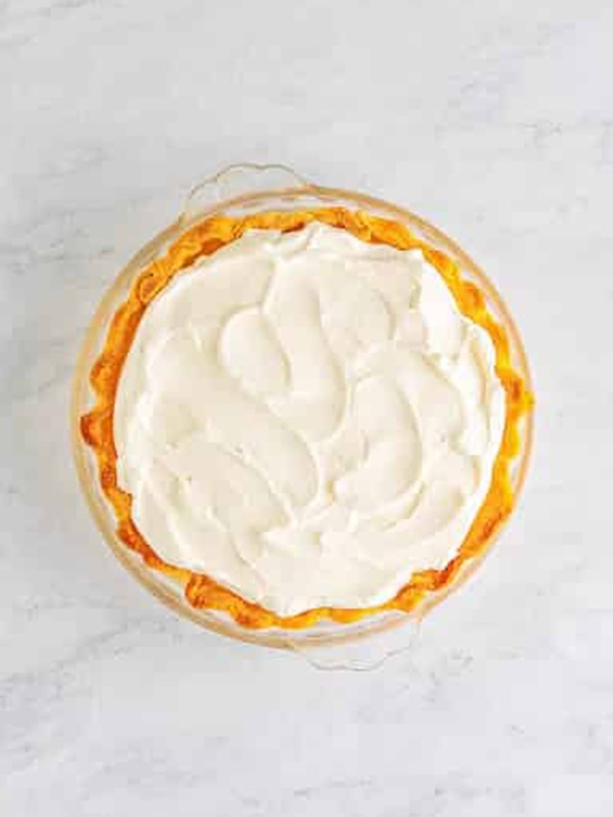 Whipped cream spread over the chilled banana cream pie.