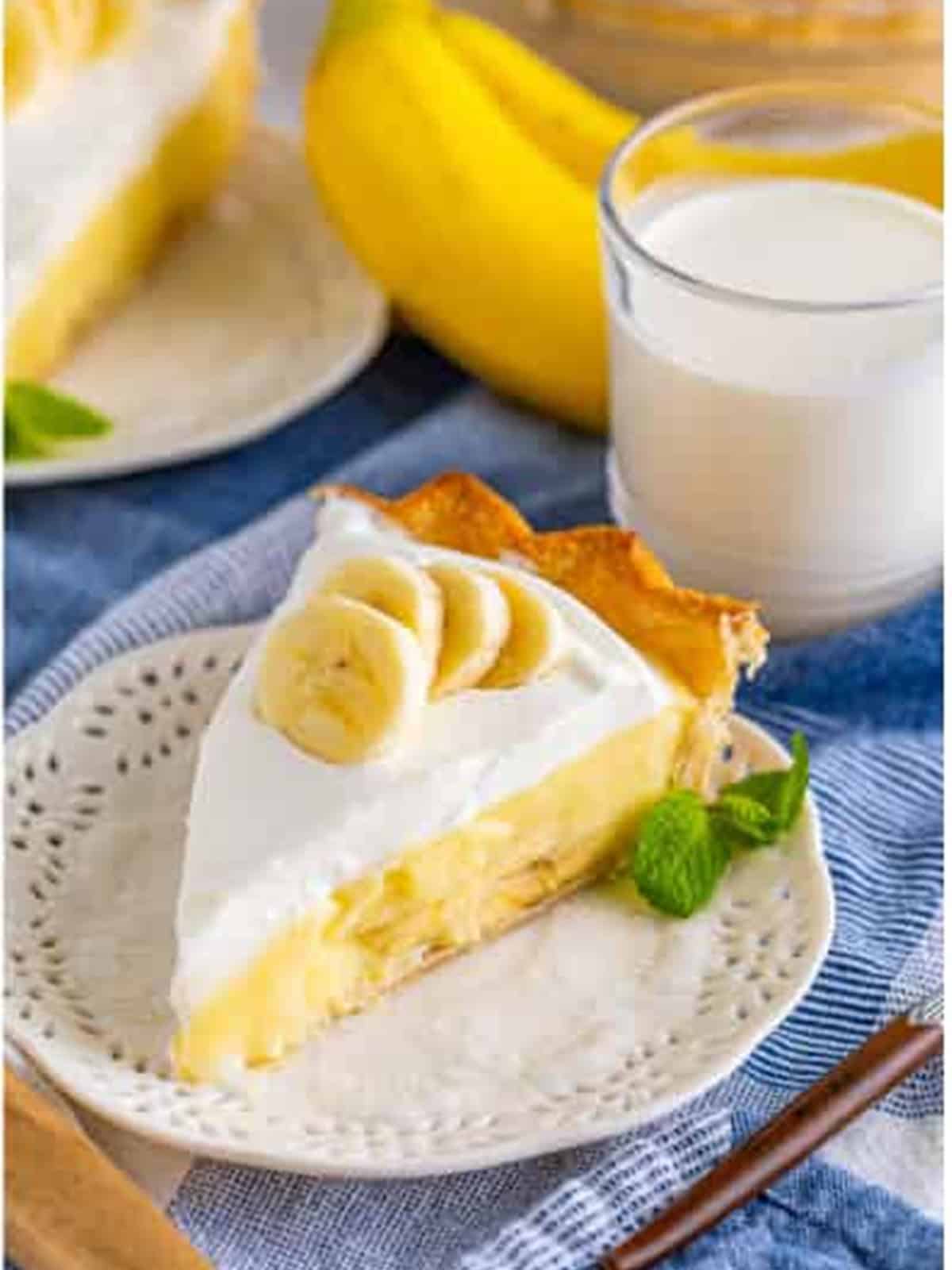 A slice of finished banana cream pie topped with whipped cream and banana slices.