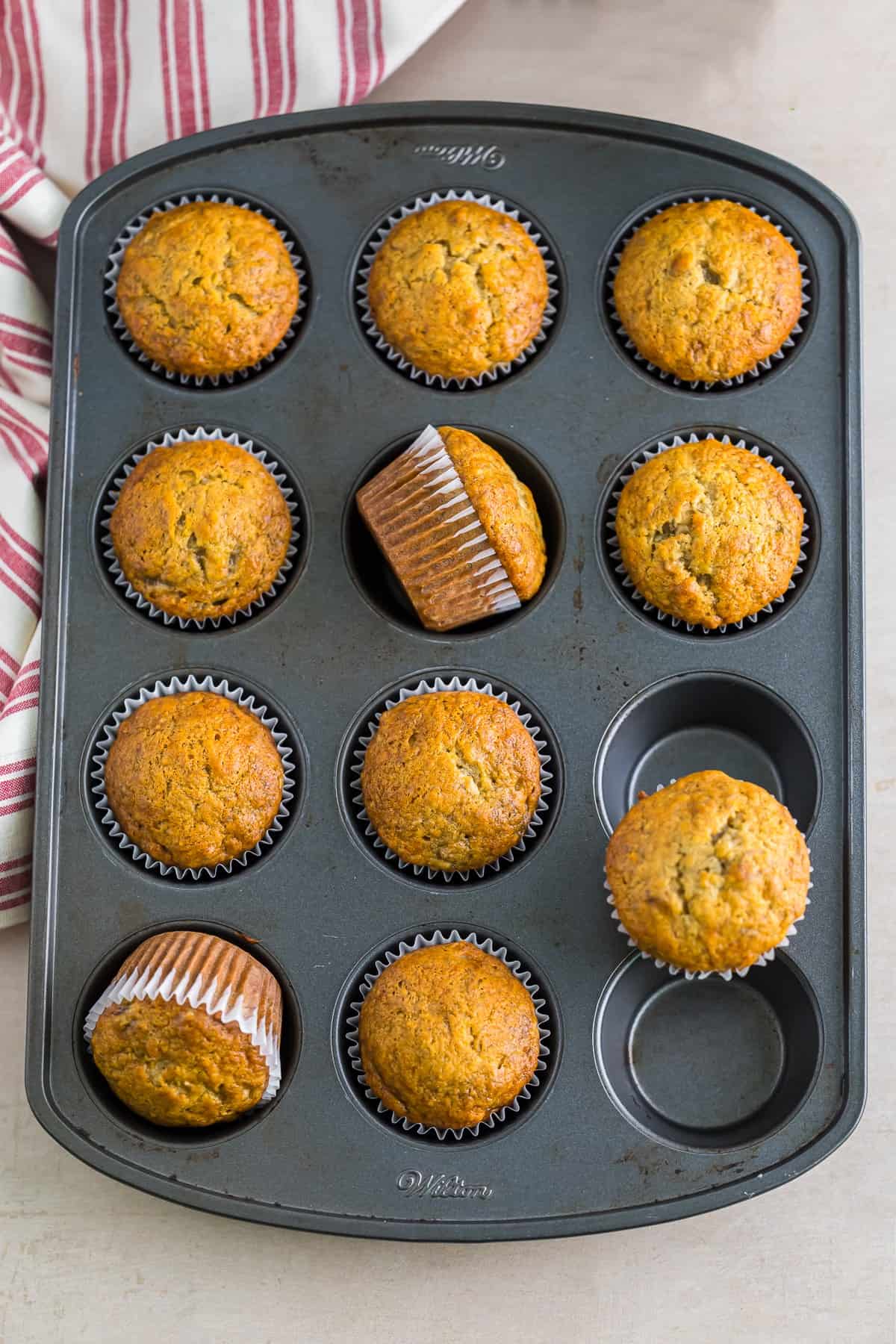 Baked banana cupcakes in a muffin tin for banana cupcakes with brown sugar frosting.