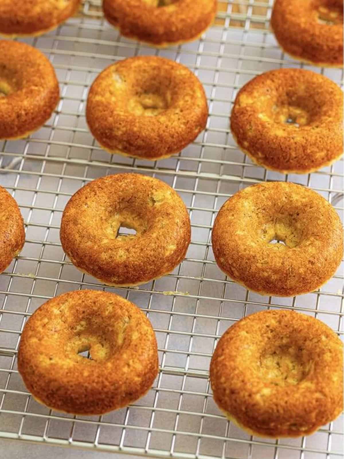 Baked banana donuts cooling on a wire rack.